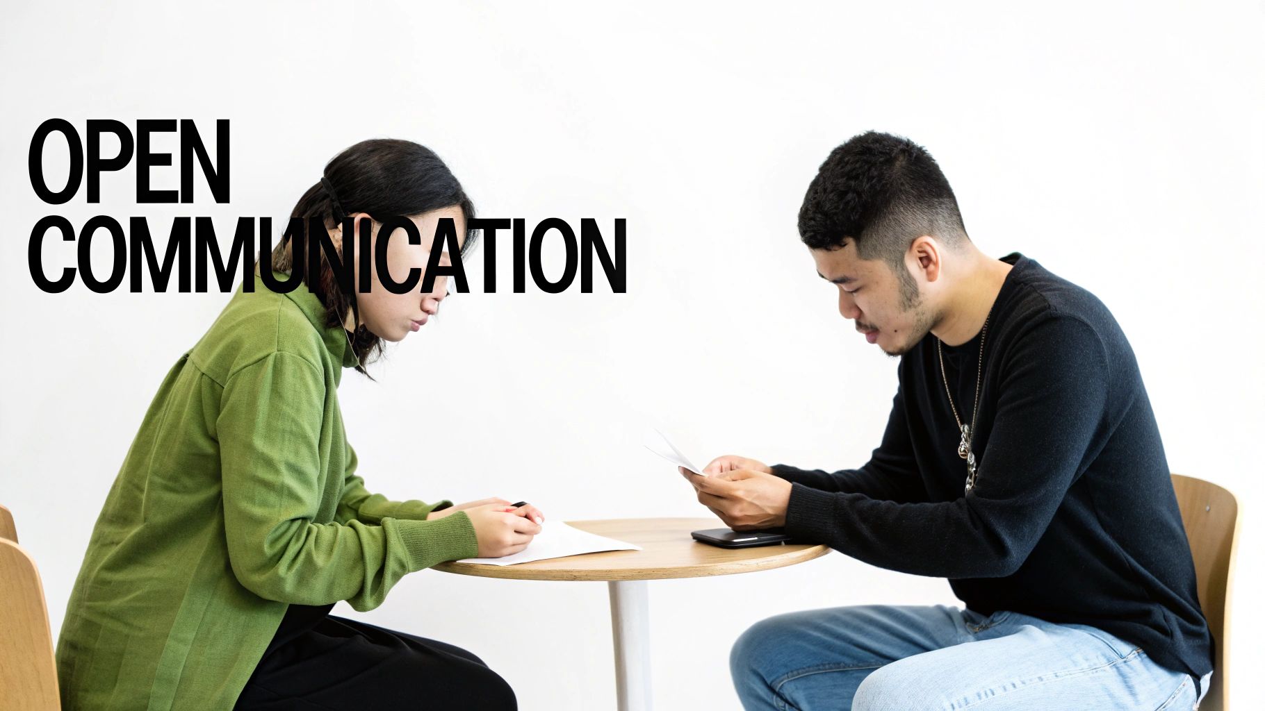 Two individuals sit at a table, focused on papers, with 'OPEN COMMUNICATION' text overlaid on the image.